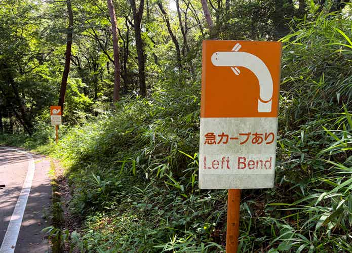 森林公園のサイクリングコースの急カーブありの看板