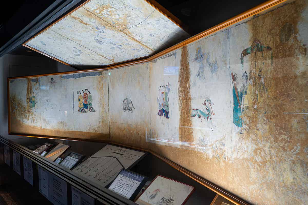 ガラスケースに展示された極彩色壁画の精密な模写
