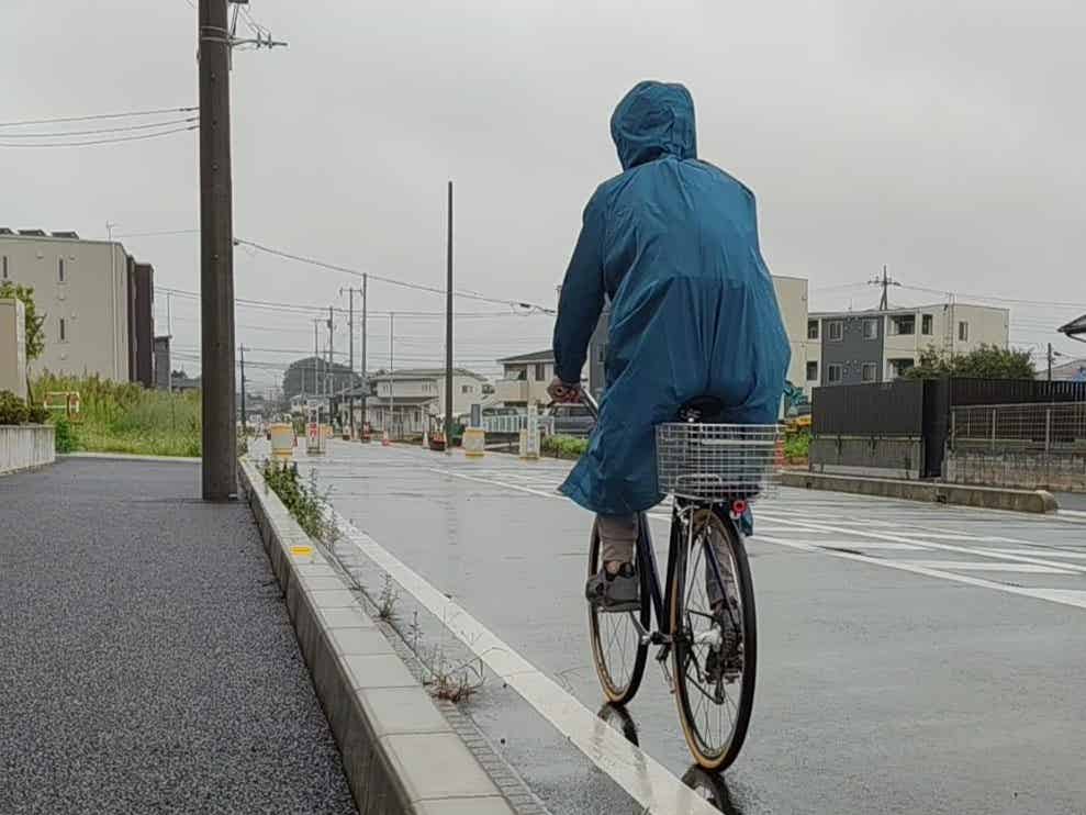 雨の日にワークマンバッグインレインコートを着て自転車で走る筆者