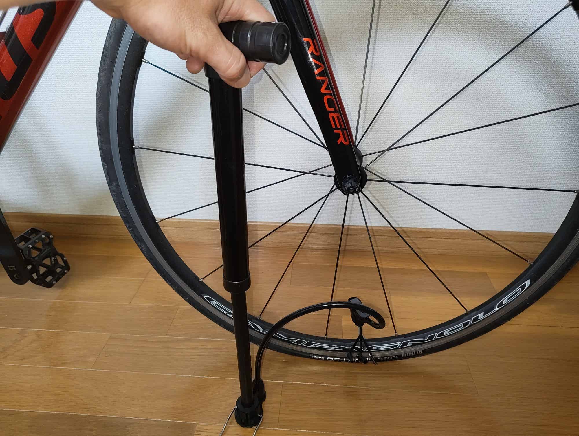 ロードバイクにワッツの空気入れを使っているところ