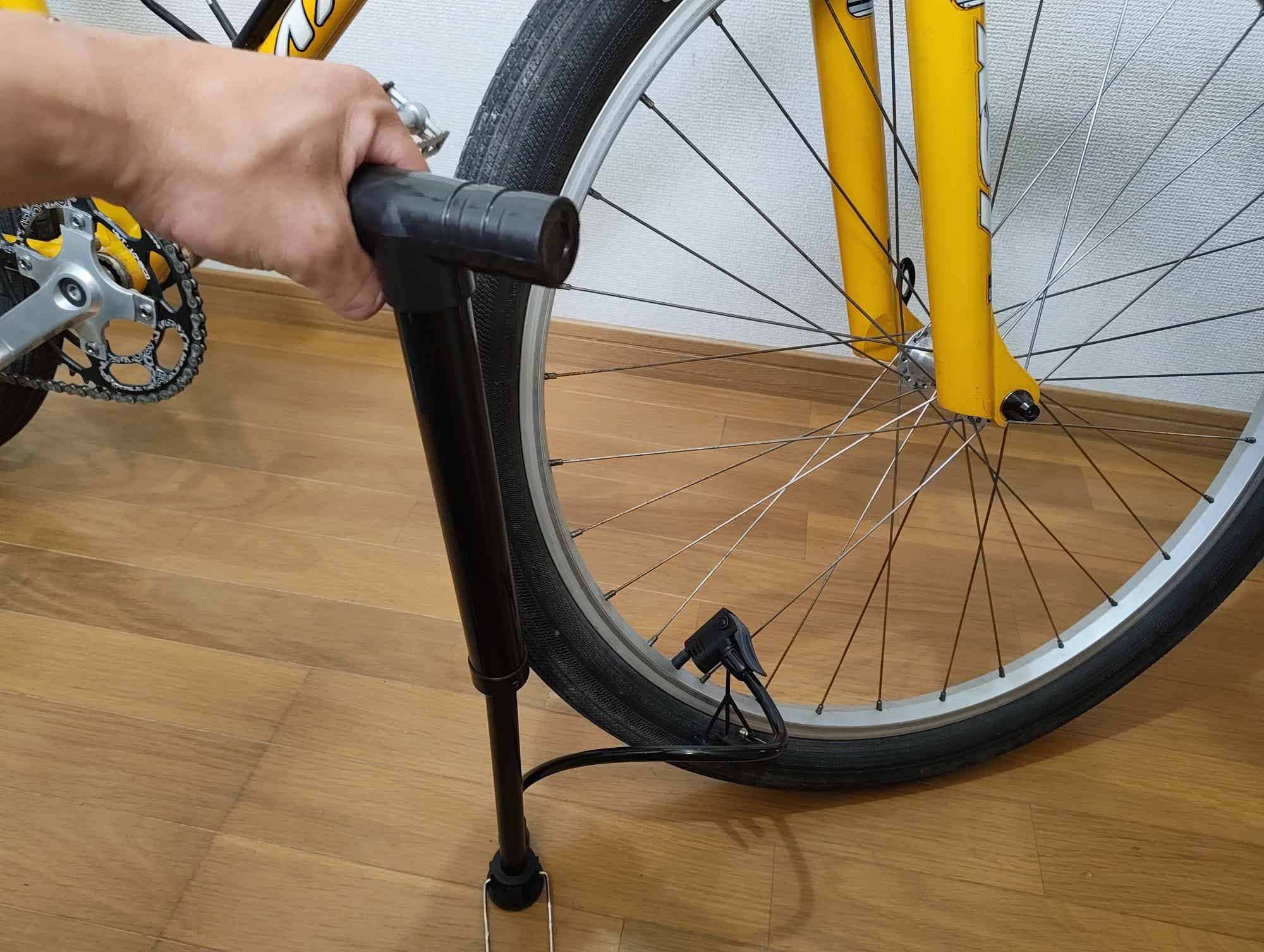 MTBのタイヤにワッツの空気入れを使っているところ