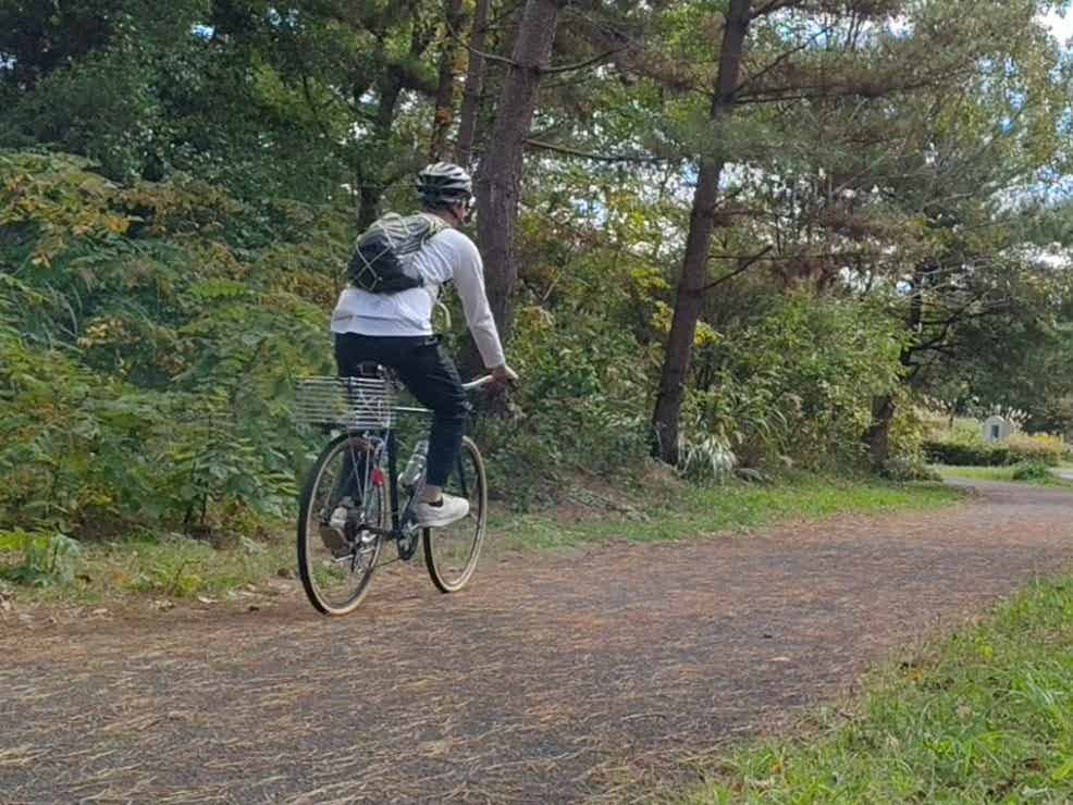 ヘルメットをかぶってひたち海浜公園のサイクリングコースを走る筆者